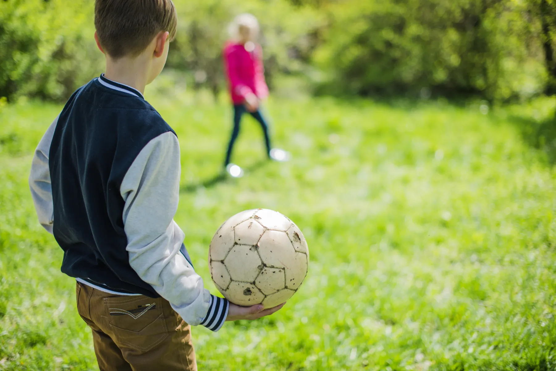 Criança a jogar futebol num relvado