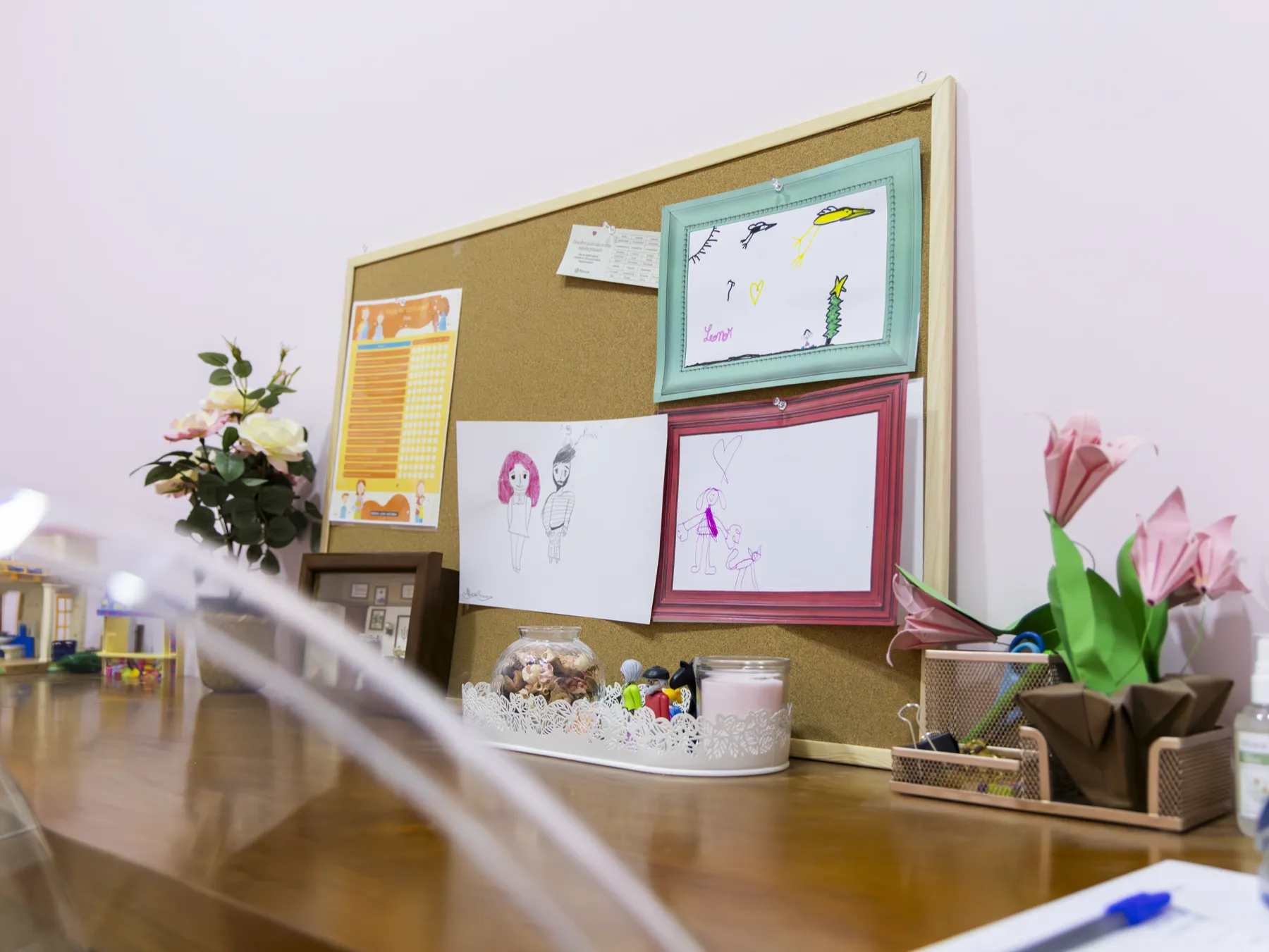 Secretária com quadro de cortiça e desenhos das crianças