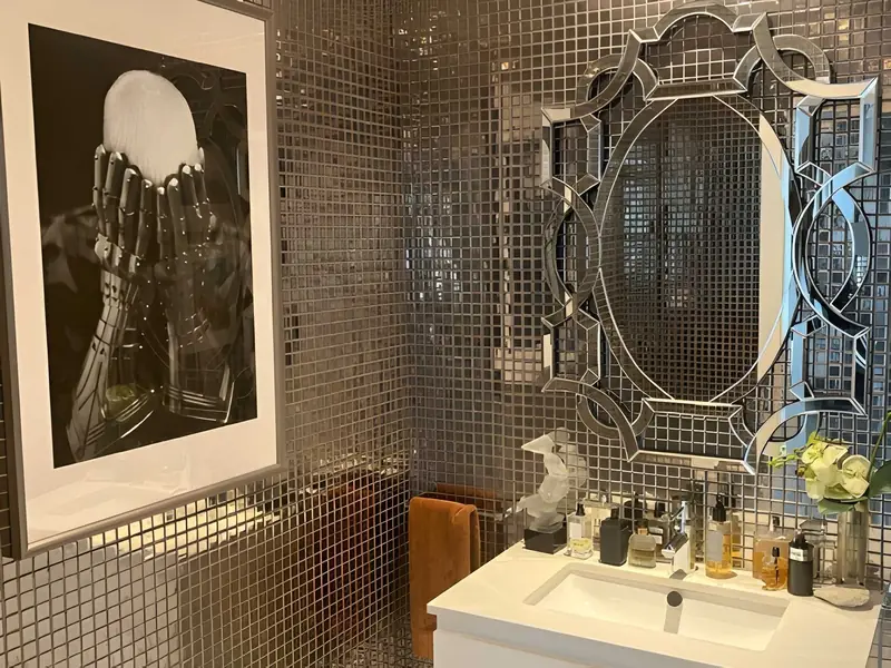 Bathroom in mirrored mosaic with a Venetian mirror and a black and white photograph