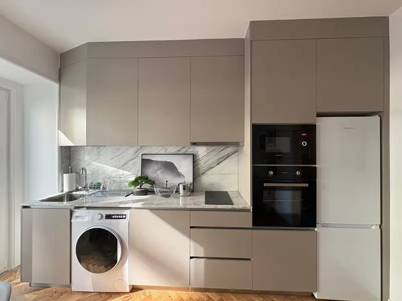 Cozinha em taupe com frente de mármore, fornos em coluna e soalho em espinha