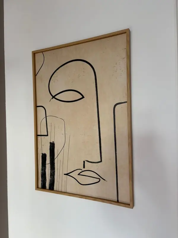 Quadro de linhas com rosto abstrato em moldura de madeira