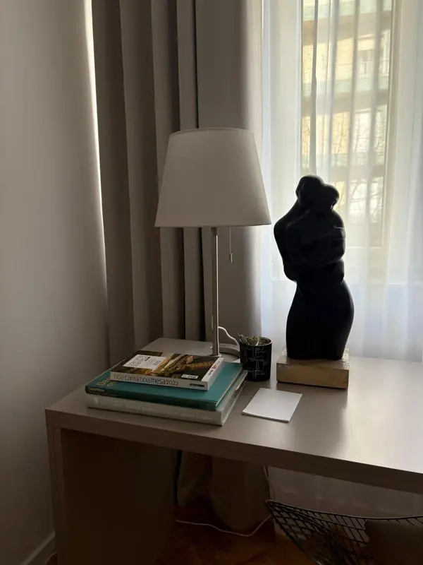 Secretária com escultura negra, livros de arte e candeeiro de tecido