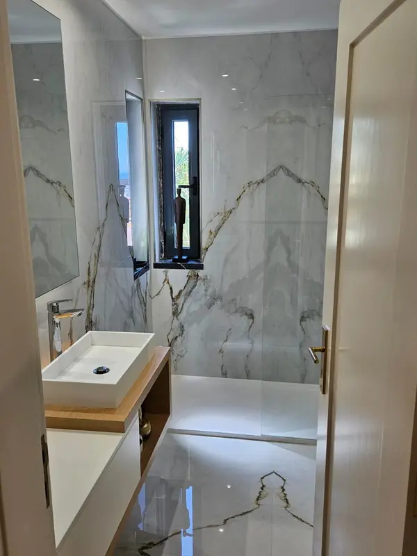 Bathroom in gold veined marble with a countertop basin