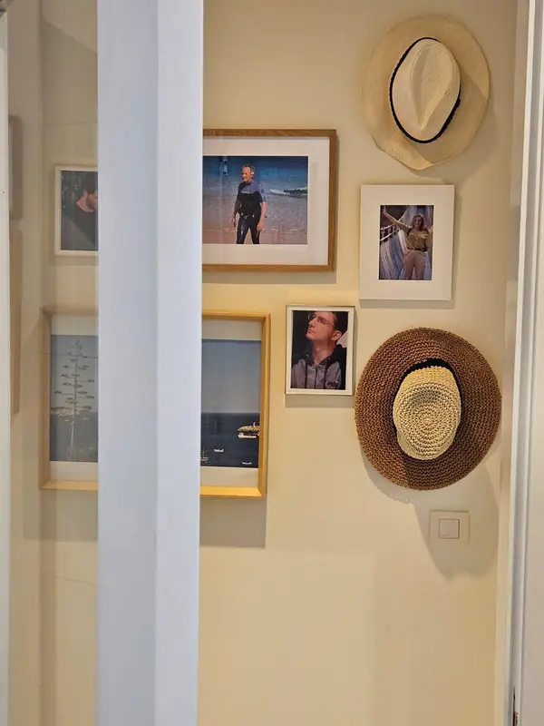 Parede de fotografias emolduradas e chapéus de palha