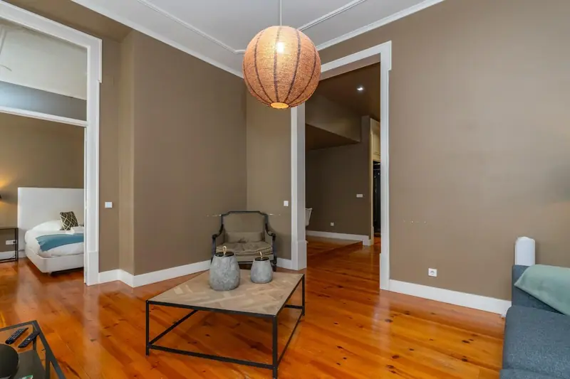 Sala de paredes taupe com cadeirão clássico e vista para o quarto